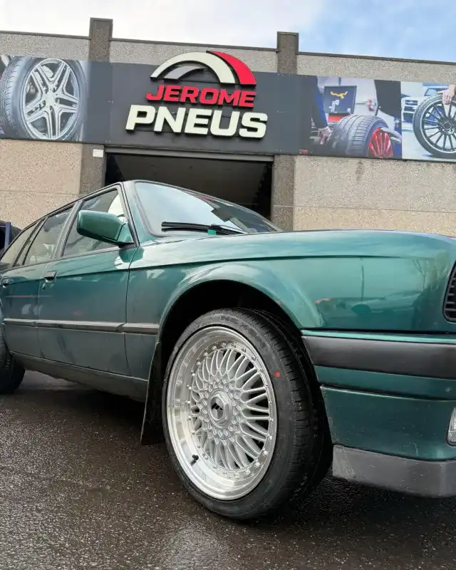 BMW E30 et jantes alu devant le garage Jérôme-Pneus à Gosselies